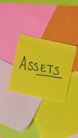 Vertical-Video-Business-Concept-Of-Revolving-Sticky-Notes-With-Assets-Written-On-Top-Note-1